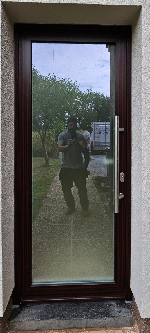 Porte d’entrée vitrée à Bruxelles avec finition sombre et design vertical